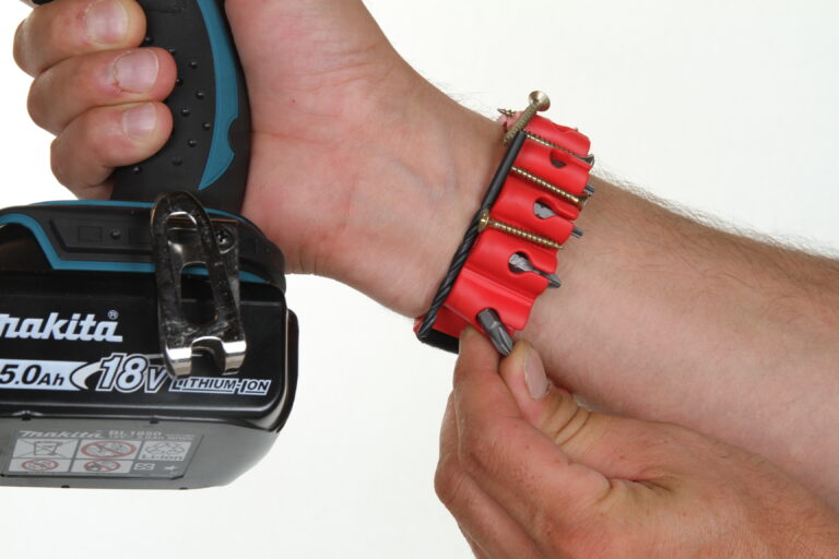 Un bracelet magnétique Bitpass au poignet de quelqu'un qui tiens une visseuse et prend un embout à une main